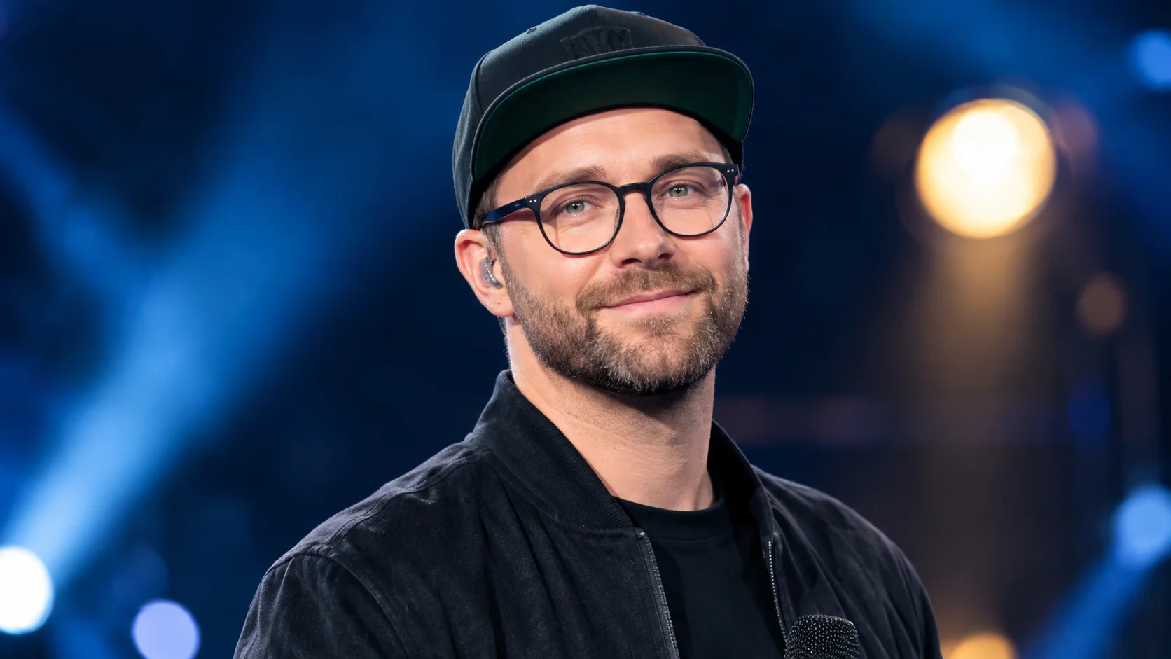 Mark Forster performing live on stage with a microphone